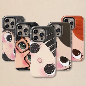 Può includere: Una collezione di custodie per telefoni con illustrazioni stravaganti di volti con grandi occhi. Le custodie presentano una varietà di tonalità della pelle, colori di capelli e design degli occhi unici, inclusi dettagli stellati e fantasia. Le custodie sono nere e hanno una finitura lucida.