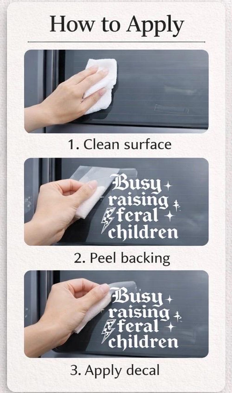 May include: A three-step instructional guide for applying a white vinyl decal to a car window. The decal features the text 'Busy raising feral children' in a gothic font, accompanied by a checkered lightning bolt and small star icons.