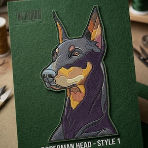 May include: Embroidered patch featuring a Doberman Pinscher's head in profile. The patch is primarily black, with tan and yellow accents. The text "DOBERMAN HEAD - STYLE 1" and "STITCHES: 84450" are displayed below the image. The patch is on a green background.