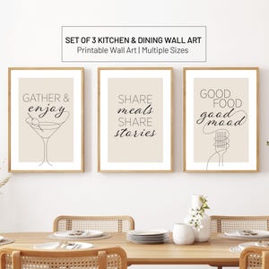 Puede incluir: Juego de tres impresiones enmarcadas para cocina y comedor. Cada impresión tiene un fondo beige con texto negro y dibujos lineales. Las impresiones dicen "GATHER & enjoy", "SHARE meals SHARE stories" y "GOOD FOOD good mood".