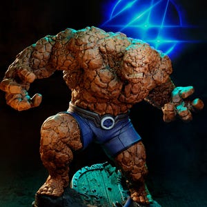 Op de afbeelding: Gedetailleerd beeldje van The Thing uit Fantastic Four. Het personage wordt afgebeeld met een rotsachtige, oranje-bruine buitenkant, gekleed in een blauwe korte broek met een gesp met een cirkelvormig logo. Het beeldje staat op een rotsachtige basis met een turquoise accent.