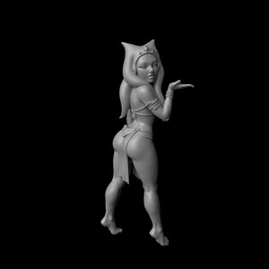 Op de afbeelding: Een grijswaarden 3D-geprinte figuur van een mensachtig personage met een hoofdtooi en lichaamsjuwelen. De figuur poseert met één arm uitgestrekt en de andere arm gebogen. De achtergrond is effen zwart.