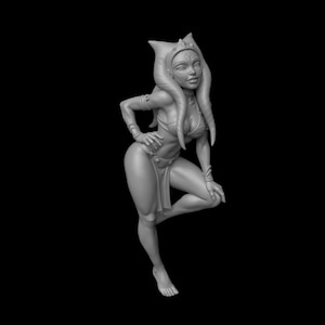 Op de afbeelding: Een grijstint beeldje van een humanoïde alien-personage met hoofdtentakels, gekleed in een bikini en beenwraps. De figuur poseert met één hand op de heup en de andere rustend op een gebogen knie, tegen een zwarte achtergrond.