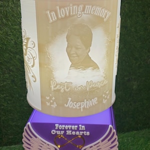 May include: A memorial light featuring a photo, the text "In loving memory", "Rest in Peace Josephine", and "Forever In Our Hearts Grandma". The light has a purple base with angel wings.