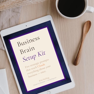 Puede incluir: Una tableta blanca muestra el texto "Business Brain Setup Kit" en un marco morado y azul marino. Est&aacute; sobre una superficie de madera clara, con una taza de caf&eacute; y una cuchara de madera. El texto dice: "Cinco indicaciones estrat&eacute;gicas que ense&ntilde;an a Claude todo sobre tu negocio."