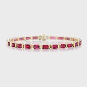 Peut inclure: Un bracelet doré orné de pierres précieuses rouges rectangulaires et vives. Les pierres sont disposées en ligne, formant une bande continue. Le bracelet est doté d'un fermoir et est présenté sur un fond neutre.