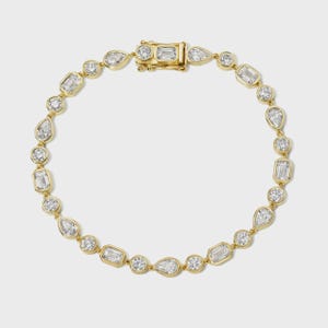 Può includere: Un bracciale in oro con una serie di diamanti incastonati in varie forme, tra cui rotondi, a goccia e smeraldo. Il bracciale è assicurato con una chiusura in oro. I diamanti sono disposti in un motivo ripetuto.