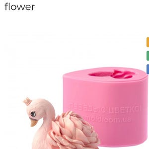 May include: A pink silicone mold and a finished swan figurine. The mold is rectangular and the swan has a flower-like body. The text "Silicone mold Swan with a flower" is at the top of the image.