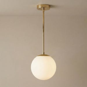 Könnte beinhalten: Ein Set aus drei Keramikbechern mit gesprenkelter, matter Oberfläche. Die Becher sind in Creme-, Hellgrau- und Dunkelgrautönen gehalten. Jeder Becher hat ein schlichtes, minimalistisches Design, perfekt für Kaffee oder Tee.