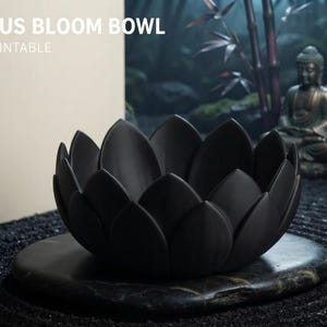 May include: A matte black bowl shaped like a blooming lotus flower with layered petals. The text LOTUS BLOOM BOWL 3D PRINTABLE is visible, along with icons and text for UNIQUE DESIGN, MULTI-USE BOWL, EASY TO PRINT, and NO SUPPORTS NEEDED.