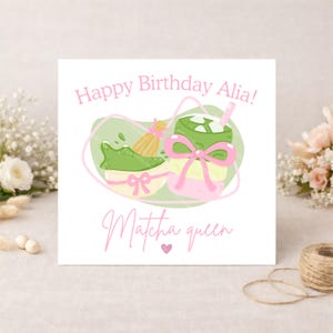 Puede incluir: Tarjeta de felicitaci&oacute;n blanca con el texto rosa "Happy Birthday Alia!". La tarjeta presenta ilustraciones de t&eacute; matcha y un batidor, con las palabras "Matcha queen" debajo. Un lazo rosa adorna la bebida de matcha.