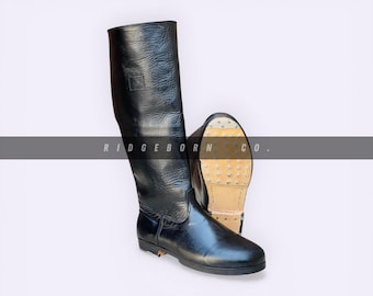 Botas de oficial de cuero negro, estilo militar hasta la rodilla.