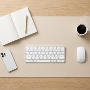 Pode incluir: Uma configuração de secretária minimalista com teclado, rato e smartphone brancos numa base de secretária bege. Um caderno, uma caneta e uma chávena de café completam o espaço de trabalho. A base da secretária tem cerca de 76 cm de comprimento.
