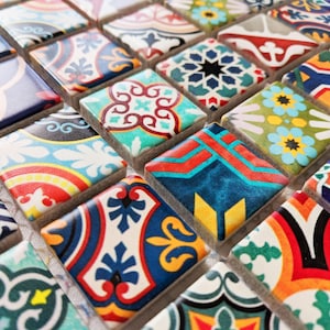May include: Close-up of a mosaic tile sheet with a variety of colourful, patterned tiles. The tiles are square and have intricate designs in shades of blue, red, green, and yellow. The mosaic is suitable for decorative purposes.