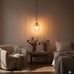 Puede incluir: Escena interior moderna con una lámpara colgante con pantalla de vidrio acanalado. La cálida luz ilumina un espacio acogedor con un sillón beige, una mesa auxiliar de madera y una cama. Jarrones decorativos con flores secas añaden un toque natural.