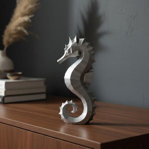 Modernes Seepferdchen als elegante Skulptur im minimalistischen Stil. Maritime Dekoration aus 3D Druck Kunststoff für Badezimmer, Wohnzimmer, Regal oder Sideboard. Stilvolle Tierfigur mit klarer Formensprache passend zu Küstenstil, Japandi oder moderner Einrichtung.
Dekorative Seepferdchen Figur als maritime Wohnraumdeko mit moderner geometrischer Optik. Ideal für Bad, Schlafzimmer oder Eingangsbereich.