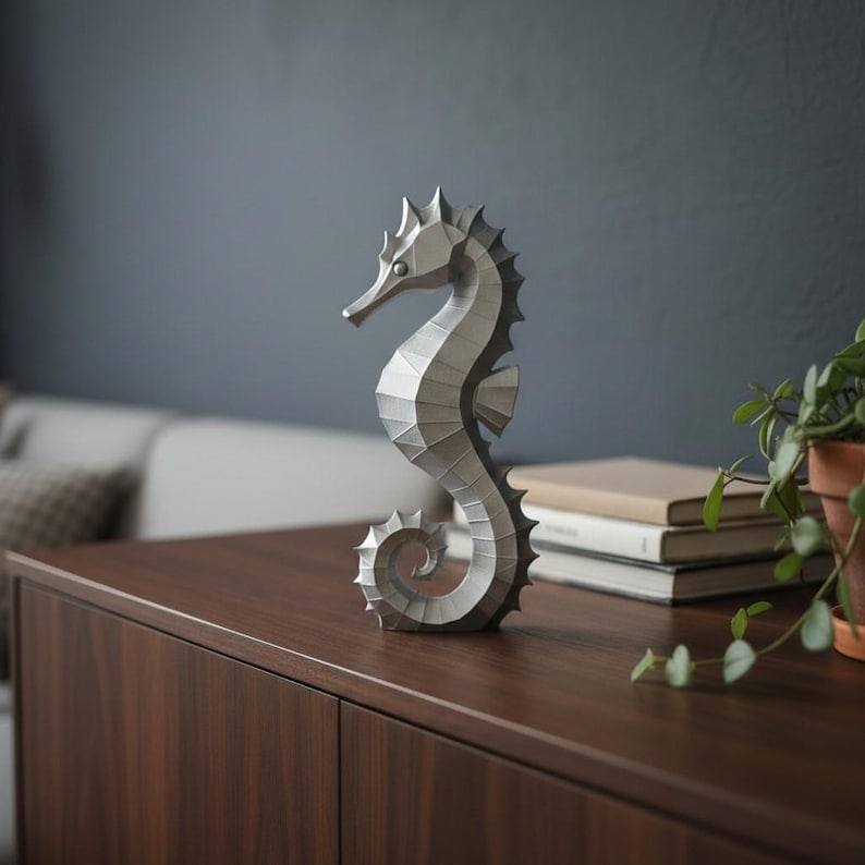 Modernes Seepferdchen als elegante Skulptur im minimalistischen Stil. Maritime Dekoration aus 3D Druck Kunststoff für Badezimmer, Wohnzimmer, Regal oder Sideboard. Stilvolle Tierfigur mit klarer Formensprache passend zu Küstenstil, Japandi oder moderner Einrichtung.
Dekorative Seepferdchen Figur als maritime Wohnraumdeko mit moderner geometrischer Optik. Ideal für Bad, Schlafzimmer oder Eingangsbereich.