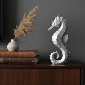 Modernes Seepferdchen als elegante Skulptur im minimalistischen Stil. Maritime Dekoration aus 3D Druck Kunststoff für Badezimmer, Wohnzimmer, Regal oder Sideboard. Stilvolle Tierfigur mit klarer Formensprache passend zu Küstenstil, Japandi oder moderner Einrichtung.
Dekorative Seepferdchen Figur als maritime Wohnraumdeko mit moderner geometrischer Optik. Ideal für Bad, Schlafzimmer oder Eingangsbereich.