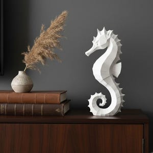 Modernes Seepferdchen als elegante Skulptur im minimalistischen Stil. Maritime Dekoration aus 3D Druck Kunststoff für Badezimmer, Wohnzimmer, Regal oder Sideboard. Stilvolle Tierfigur mit klarer Formensprache passend zu Küstenstil, Japandi oder moderner Einrichtung.
Dekorative Seepferdchen Figur als maritime Wohnraumdeko mit moderner geometrischer Optik. Ideal für Bad, Schlafzimmer oder Eingangsbereich.