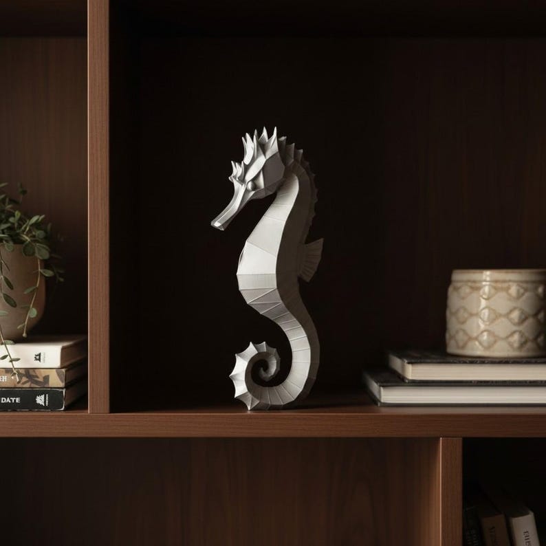 Modernes Seepferdchen als elegante Skulptur im minimalistischen Stil. Maritime Dekoration aus 3D Druck Kunststoff für Badezimmer, Wohnzimmer, Regal oder Sideboard. Stilvolle Tierfigur mit klarer Formensprache passend zu Küstenstil, Japandi oder moderner Einrichtung.
Dekorative Seepferdchen Figur als maritime Wohnraumdeko mit moderner geometrischer Optik. Ideal für Bad, Schlafzimmer oder Eingangsbereich.