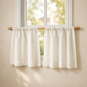 Puede incluir: Un par de cortinas de caf&eacute; de color blanco roto hechas de una tela texturizada, fruncidas en una barra de madera de color marr&oacute;n claro. Las cortinas cuelgan en pliegues verticales, cubriendo la parte inferior del marco de la ventana.