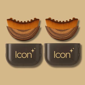 Pode incluir: Duas escovas de maquilhagem com cerdas castanhas e um cabo com efeito de madeira, emparelhadas com duas caixas castanhas escuras. As caixas t&ecirc;m a palavra "Icon" em letras douradas, com um gr&aacute;fico de estrela. As escovas s&atilde;o projetadas para aplicar maquilhagem.