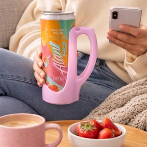 May include: A white ceramic mug with a black handle and the text "But First, Coffee" in a handwritten style. The mug is on a white surface. The mug is approximately 4 inches tall.