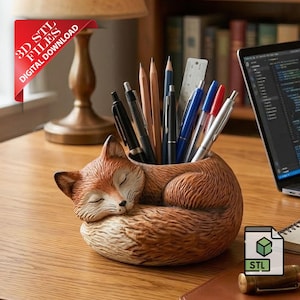 May include: A brown and tan fox-shaped pen holder with a sleeping fox design. The pen holder is filled with pens, pencils, and a ruler. A laptop and notepad are in the background. The image includes a red banner that says "3D STL FILES DIGITAL DOWNLOAD".