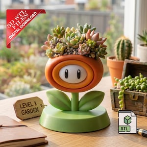 Op de afbeelding: Een 3D-geprinte oranje en groene plantenpot in de vorm van een bloem met een wit ovaal midden, gevuld met diverse kleine vetplanten. Een houten label bevat de tekst LEVEL 1 GARDEN. Een rode banner vermeldt 3D STL FILES DIGITAL DOWNLOAD.