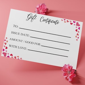 May include: A white rectangular gift certificate with black text reading Gift Certificate, TO, ISSUE DATE, AMOUNT / GOOD FOR, and WITH LOVE. The card features small pink and red heart illustrations along the edges and two pink flower blossoms.