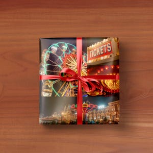 May include: A white ceramic mug with a black handle and the text "But First, Coffee" in a bold, black font. The mug is set against a blurred background, suggesting a cosy setting.