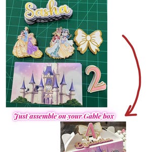 Puede incluir: Un conjunto de recortes de papel en capas que incluye el nombre Sasha en purpurina dorada, ilustraciones de princesas, un lazo blanco, una escena de castillo y el número 2. Una caja tipo gable montada muestra estos elementos con un nombre y el número 4.