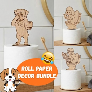 May include: Wooden roll paper decor bundle featuring dog designs. One dog holds toilet paper, another sits on a toilet using a phone, and a third reads a newspaper. The bundle includes an orange oval with the text "ROLL PAPER DECOR BUNDLE".