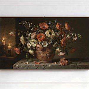 May include: A framed painting of a floral still life. The artwork features a terracotta vase overflowing with colorful flowers, including red poppies and white daisies. Two lit candles are visible in the background, adding a warm glow to the scene.