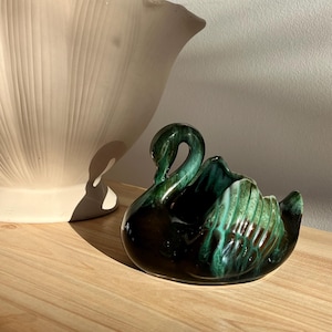 May include: A set of three ceramic mugs with a speckled, matte finish in cream, light grey, and dark grey. Each mug has a simple, minimalist design and a rounded handle.