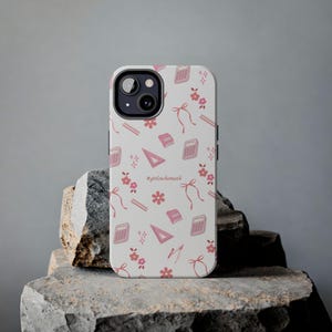 May include: A light gray smartphone case featuring a repeating pattern of pink math-themed icons including calculators, rulers, compasses, books, bows, and flowers, with the text #girlswhomath printed in the center of the design.