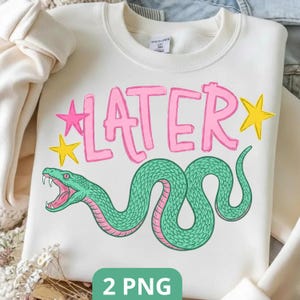 May include: Cream-coloured sweatshirt featuring the word "LATER" in pink bubble letters, with pink and yellow star accents. A green snake with pink detailing is below the text. The bottom of the image has the text "2 PNG".