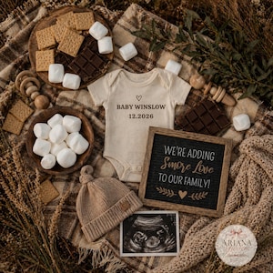 Könnte beinhalten: Baby-Ankündigung mit einem beigen Body mit dem Aufdruck "BABY WINSLOW 12.2026", Marshmallows, Schokolade, Keksen, einer Strickmütze und einem Schild mit der Aufschrift "WE'RE ADDING S'MORE LOVE TO OUR FAMILY!". Ein Ultraschallbild ist ebenfalls vorhanden.
