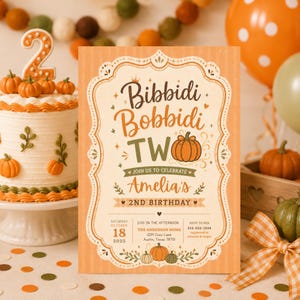May include: A rectangular birthday invitation card with a light orange striped background and a decorative cream-colored frame. The text reads Bibbidi Bobbidi TWO, Join us to celebrate Amelia's 2nd birthday, Saturday October 18 2025, 2:00 in the afternoon.