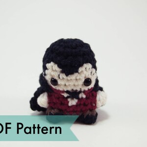 May include: Crochet amigurumi pattern for a vampire with black hair, a red shirt, and white skin. The pattern is available as a PDF download.