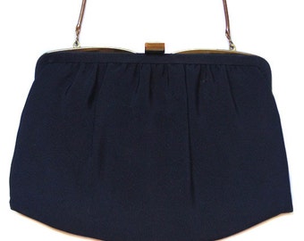 May include: A black fabric clutch purse with a gold chain strap and a gold clasp.