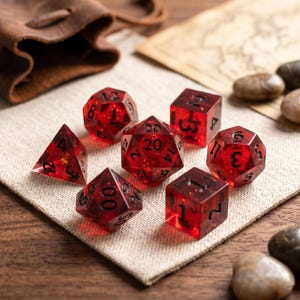 以下が含まれることがあります： テーブルトークRPG用に設計された、黒い数字が入った7つの赤い多面体サイコロのセット。 透明なサイコロにはキラキラとしたインクルージョンがあり、ベージュのリネン生地の上に置かれています。 革のポーチと地図が背景にあります。