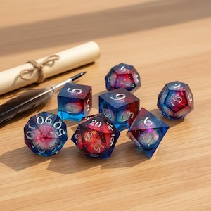 May include: A set of seven polyhedral dice for tabletop games. Each die is a transparent blue with a swirling galaxy design in red, pink, and white. The dice are arranged on a wooden surface.
