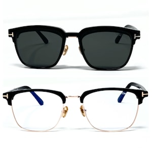 May include: Two pairs of eyeglasses. The top pair is sunglasses with black frames and dark lenses. The bottom pair has a black upper frame, gold-colored lower frame, and clear lenses. Both pairs have the brand's logo on the temples.