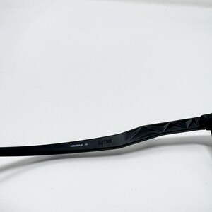 May include: Black eyeglasses arm with the brand name "SUTRO" printed on the side. The arm has a geometric design and the model number "DC0406A-33 140" is also visible.