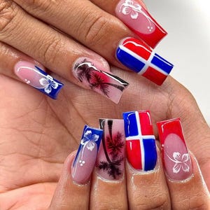 May include: A set of long, square-shaped acrylic nails. The nails feature a variety of designs, including a red, white, and blue flag, palm trees, and white floral accents. The nails have a glossy finish.