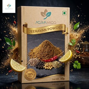 Peut inclure: Boîte de produit 'Jeeravan Powder' d'Agriamigo, avec un tas de poudre brune, d'épices et de tranches de citron. La boîte est beige avec des accents dorés et le texte '100% Pure Spices'. Poids net 50g.