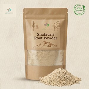 May include: A brown paper bag of Shatavari Root Powder with a clear window, a small pile of powder in front. The bag has a label with the text "Shatavari Root Powder" and a green "100% Natural" seal.