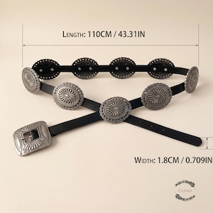Puede incluir: Un cintur&oacute;n negro con detalles circulares plateados tipo concho y una hebilla rectangular a juego. El cintur&oacute;n mide 110 cm de largo y 1,8 cm de ancho, con texto en la imagen que indica estas dimensiones exactas del producto.