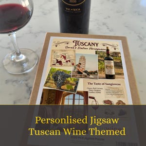 Può includere: Un puzzle a tema vino toscano con una bottiglia di vino e un bicchiere di vino rosso. Il puzzle presenta immagini della Toscana, Italia, e il testo "Tuscany Sarah's Italian Honeymoon". Il puzzle è di 1000 pezzi.
